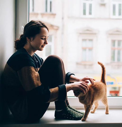 Woman with white pants walking brown dog